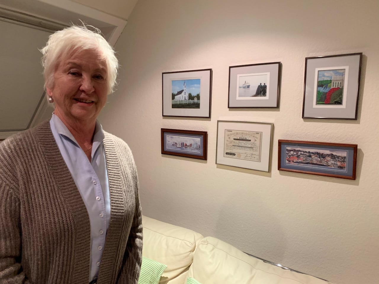 Elizabeth Sandomeer, 74, stands next to her wall of photos of memorable Canadian locations in her home in Hamburg, Germany. (Brian Goldman/CBC)