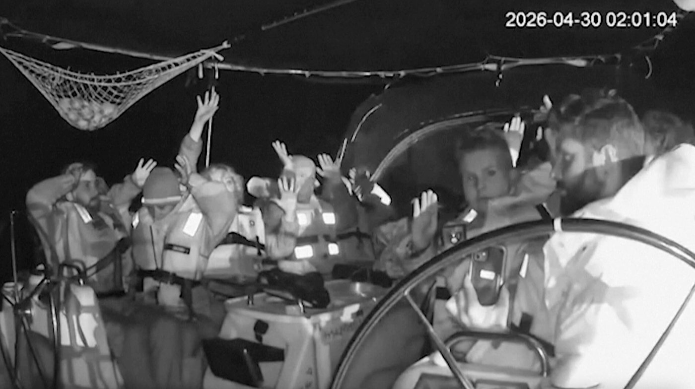 This grab from black and white CCTV footage shows members on flotilla boat with hands in air as Israeli forces intercepted activists who set sail earlier this month from Barcelona attempting to break Israel's maritime blockade of Gaza, near the southern Greek island of Crete, early Thursday, April 30, 2026. (Global Sumud Flotilla via AP)