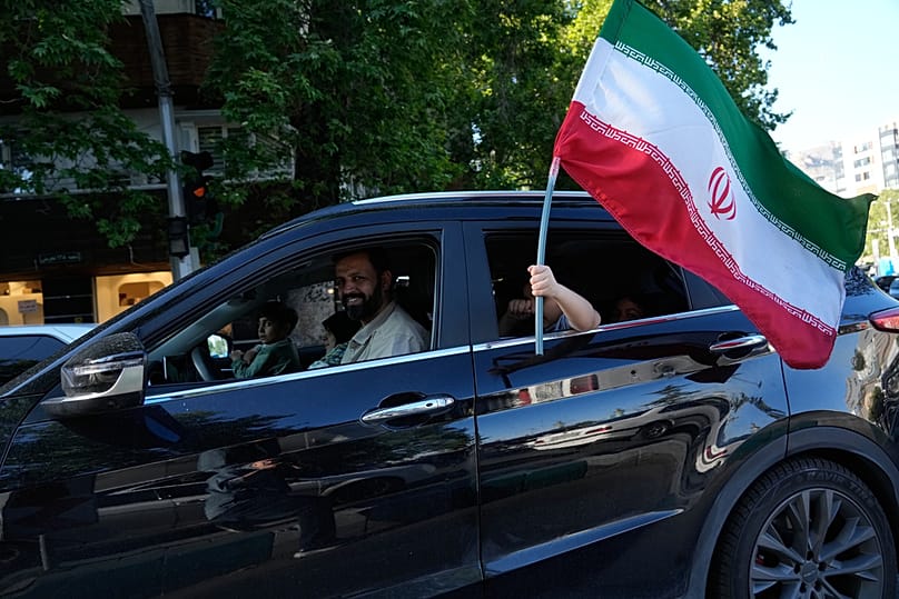 A child holds an Iranian flag through the window of a vehicle in northern Tehran, Iran, Friday, May 1, 2026 Vahid Salemi/Copyright 2026 The AP. All rights reserved