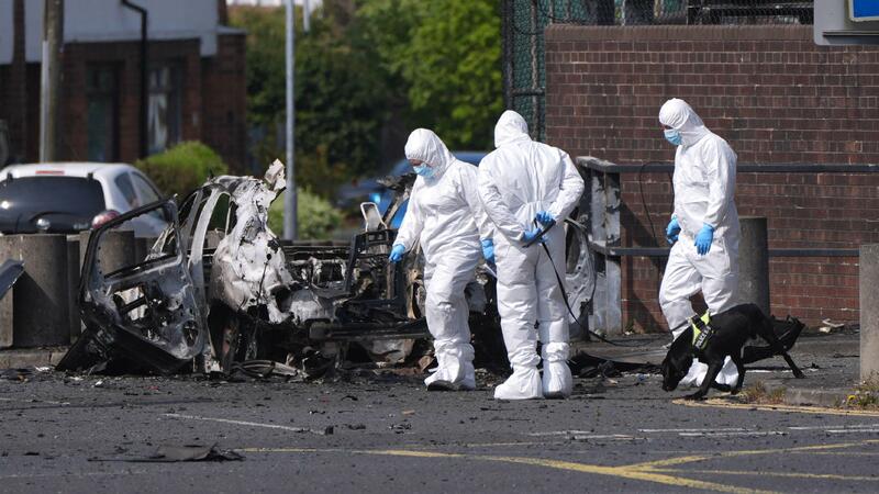 Forensic investigators at the scene in Dunmurry in Northern Ireland after a car explosion