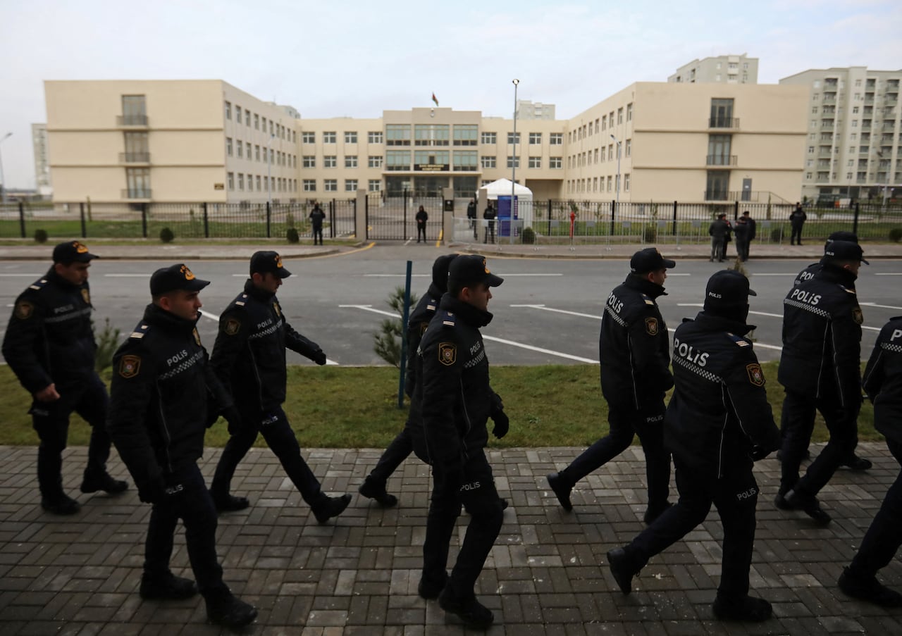 Police officers walk outside a courthouse on the day of the trial of former political figures and officials of the breakaway region of Nagorno-Karabakh, accused of various charges, including genocide and war crimes, in Baku, Azerbaijan in January 2025. The EU Parliament recently called for the release of Armenian political prisoners, something Canada has done as well. (Aziz Karimov/Reuters)