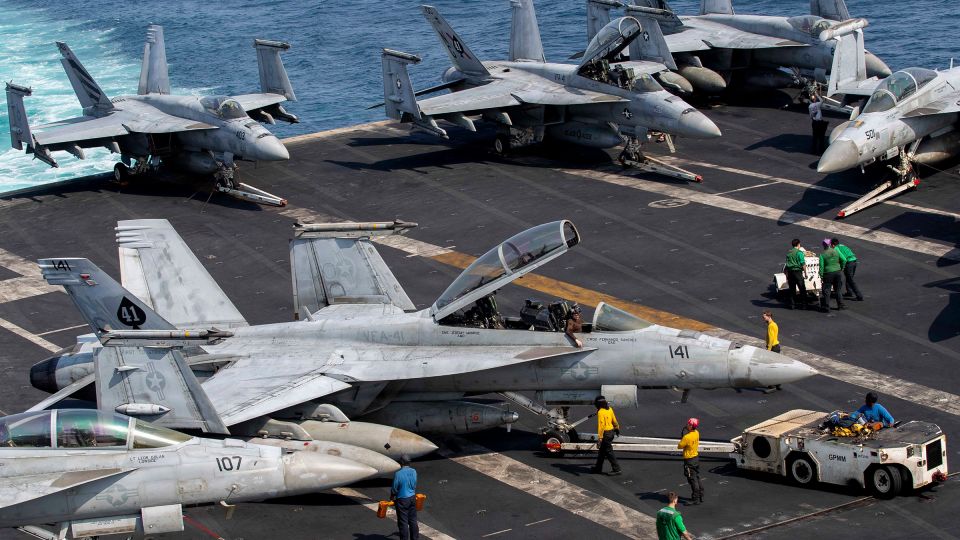 Sailors taxi an F/A-18F Super Hornet on the flight deck of the USS Abraham Lincoln aircraft carrier, during operation against Iran, on March 17.
