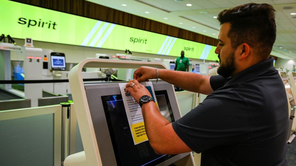 An employee sticks a Spirit Airlines operational update notice at Orlando International Airport on May 2, 2026. - Miguel Rodriguez/Reuters