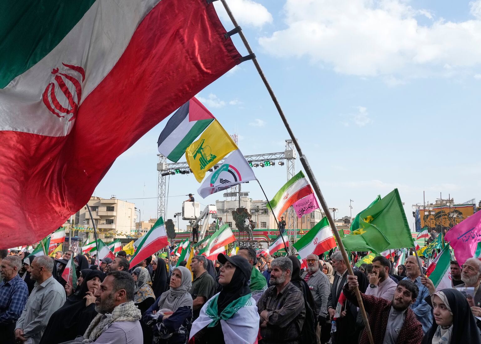 A man waves a representation of the Iranian flag during a state-organised rally in Tehran (Vahid Salemi/AP)