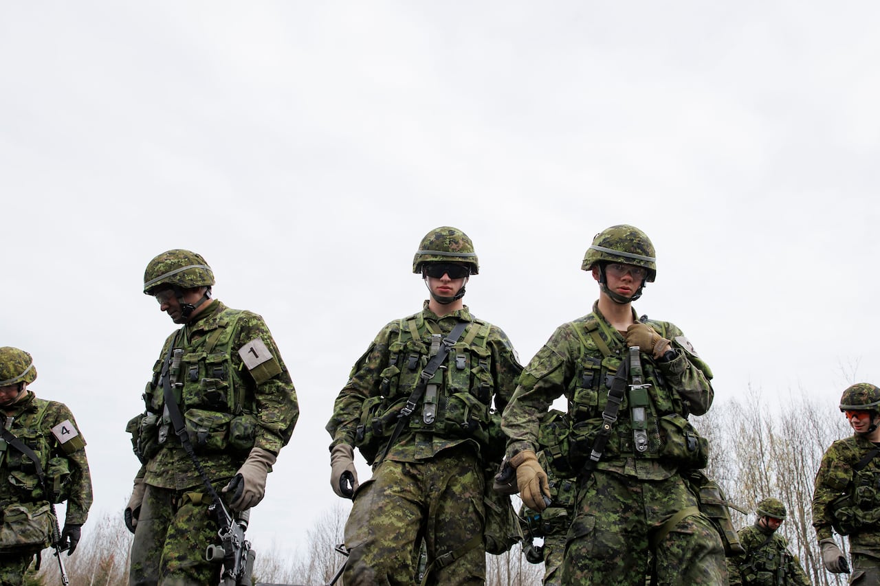 Recruits on a field course sweep for dropped belongings during basic military training (BMQ) at the Canadian Forces Leadership and Recruit School in Saint-Jean-sur-Richelieu, Que., on April 29, 2024.