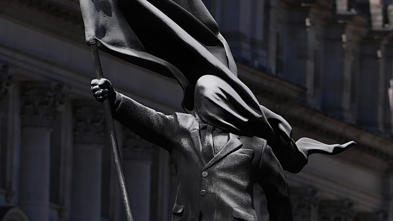 A statue of a man holding a flag covering their face, and signed 'Banksy', which has appeared in Waterloo Place in London, Thursday, April 30, 2026