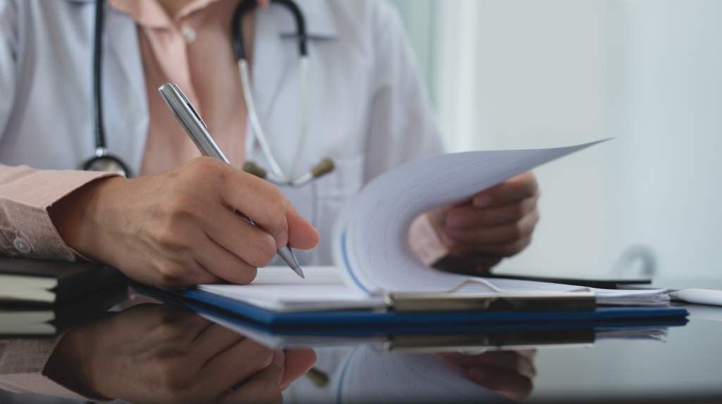 A doctor taking notes in a room in a hospital.