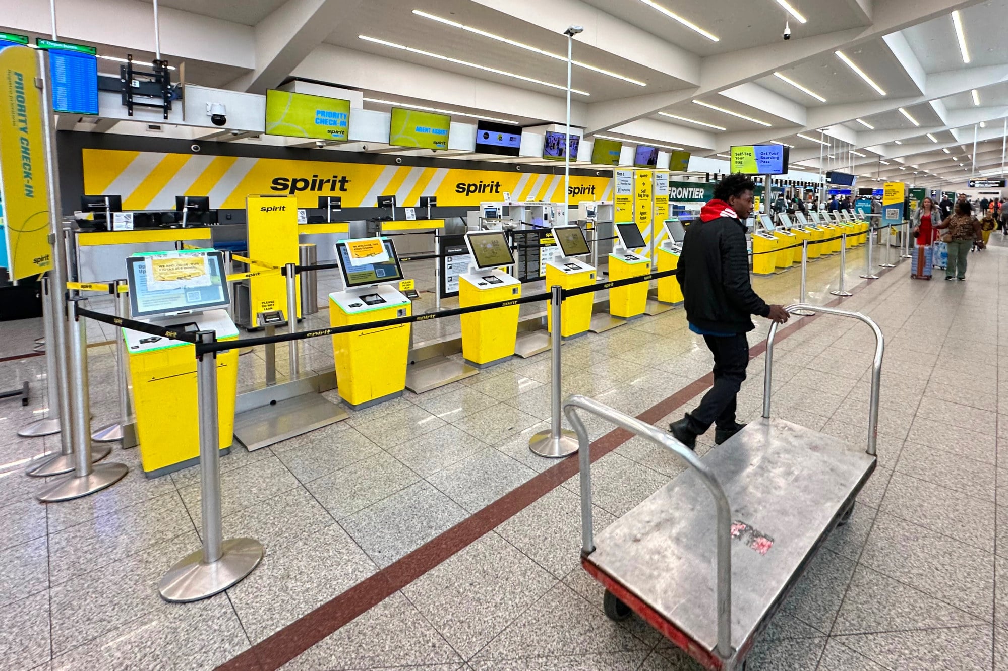 An airport employee passes the Spirit Airlines counter at Hartsfield-Jackson Atlanta International Airport after the carrier shut down on Saturday. Photo: AP